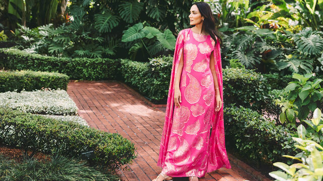 Model in pink long caftan in tropical setting